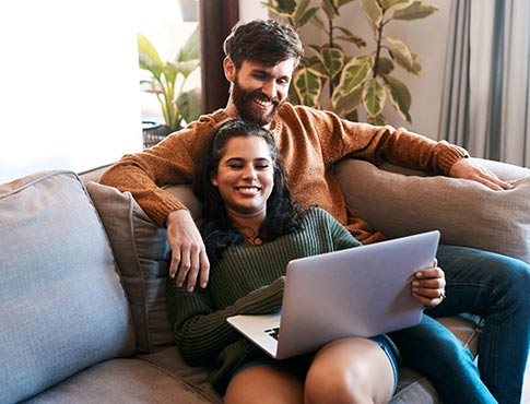 Young couple on laptop at home.